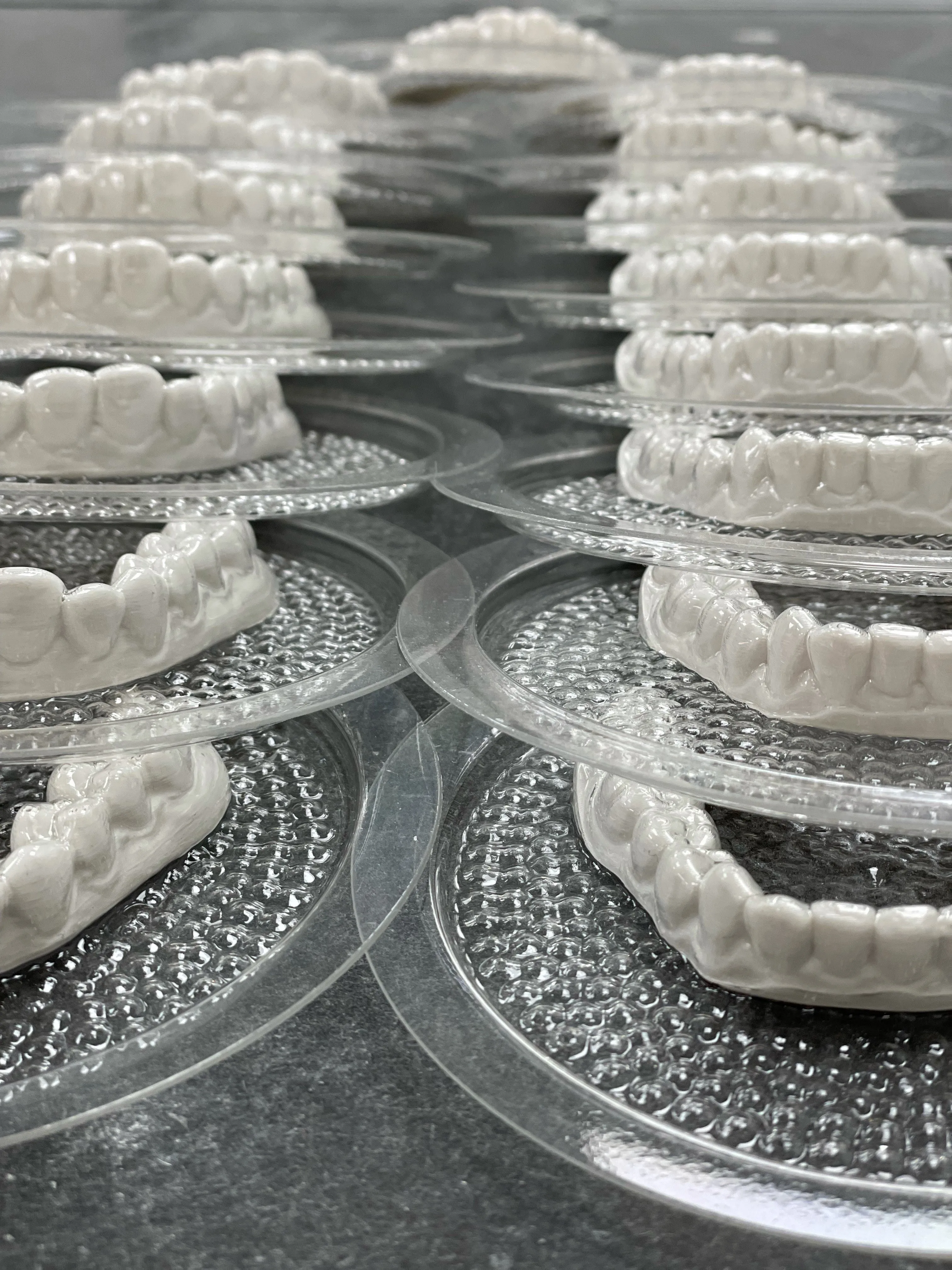Clear aligners and retainers on trays in our lab