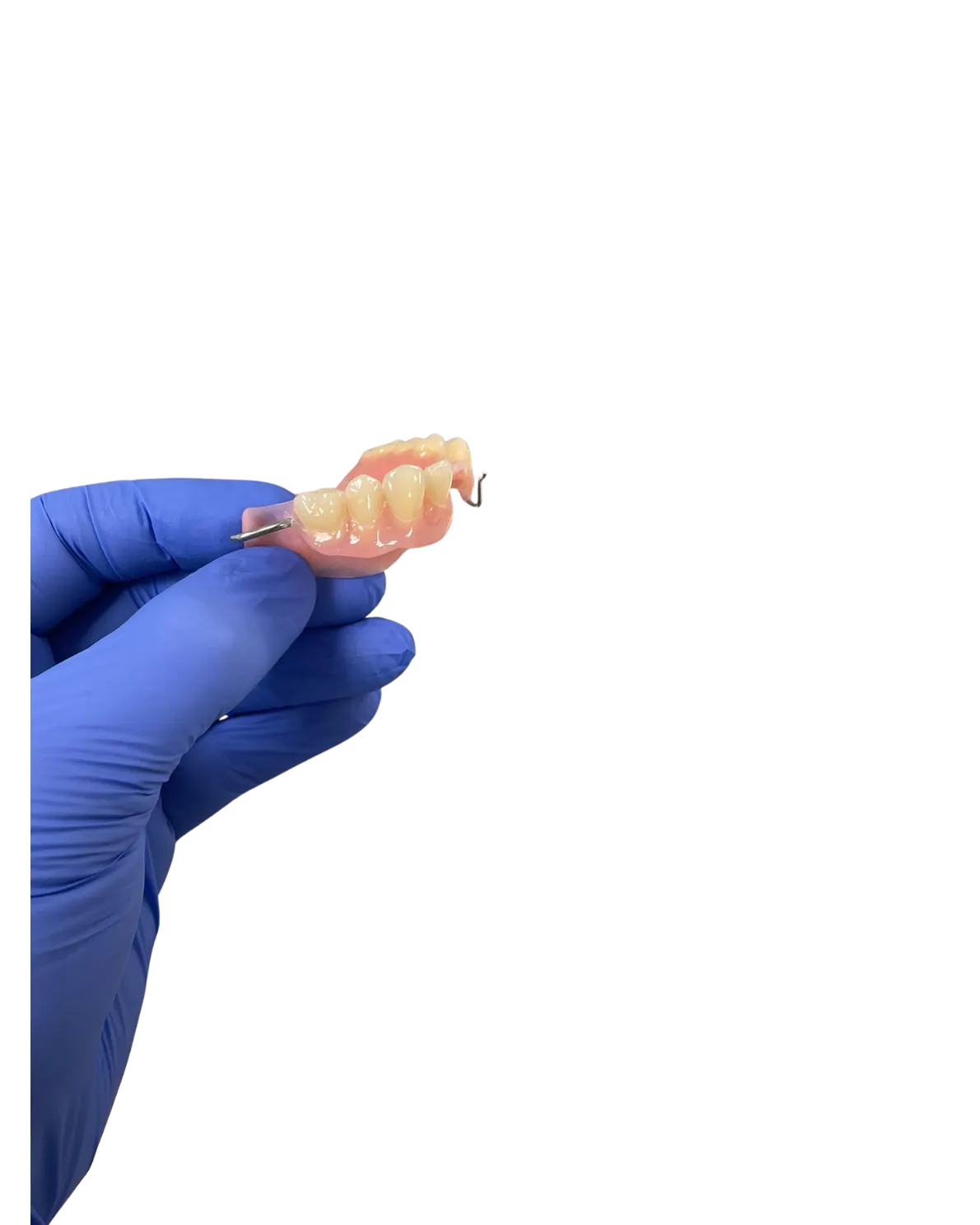 A custom partial denture with a metal clasp, held in a gloved hand in our UK laboratory